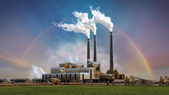 Picture of an industrial plant with a rainbow in the background